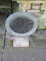 A composition stone three sectional bird bath with baluster pedestal, circular top on square stepped