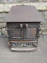 A cast iron wood/log burning stove, 62cm high x 60cm wide x 50cm deep