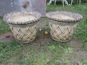 A pair of weathered good quality cast composition stone garden planters in the form of circular