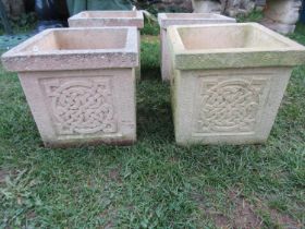 A run of four weathered cast composition stone planters of square cut form with Celtic knot panels