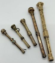 Five Victorian gothic cased antique yellow metal propelling pencils with gem set terminals,