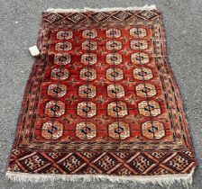 A Turkoman rug with four rows of elephant foot guls on a faded pink ground, 140 x 106cm approx