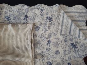 Machine made reversible quilt with toile de jouy type print on one side and contrasting stripe verso