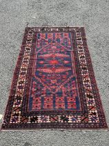 A Kasack carpet with a central stylised medallion on a red and blue ground, 188cm x 100cm