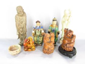 Seven oriental figures in wood, clay and soapstone and a single soapstone carved bowl.