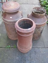 Two weathered vintage milk churns (one lacks cap) together with a canon barrel shaped chimney pot 62