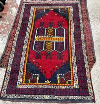 A Kazak style carpet with a central repeating rhombic pattern with a red panel and geometric