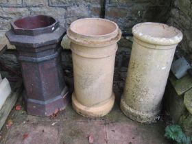 A weathered mat glazed octagonal chimney pot 62 cm high, together with two further cylindrical