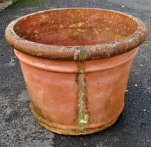 A large weathered terracotta circular ribbed planter with rolled flared rim, 84 cm diameter x 72