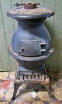 A cast iron pot bellied stove raised on swept supports, 84cm (full height)