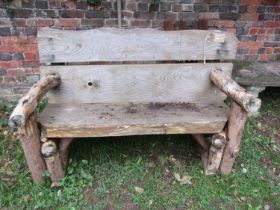 A rustic two seat garden bench with thick heavy boarded seat and back 146 cm wide