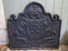A heavy vintage cast iron fire back of rectangular arched form with raised relief armorial shield,