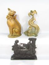 A brass Regency style dolphin doorstop, a cast iron door stop of a religious nature and a brass