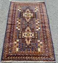 An old Baluchi rug with a pair of elongated central medallions in tones of brown and blue, 137 x