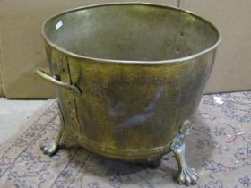 A large, riveted twin-handled brass coal bucket, raised on four paw supports, 34 cm high, 40 cm