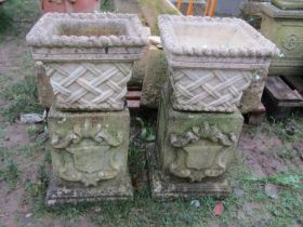 A pair of weathered cast composition stone square tapered planters in the form of lattice baskets