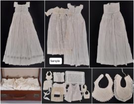 Suitcase containing a early 20th century baby clothing including full length gowns embellished