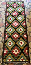 A Maimana Kilim runner in tones of mustard and green repeating medallions, 203cm x 64cm