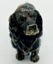 A Chinese cast brass figure of an otter with a prunus sprig, together with a cold painted bronze