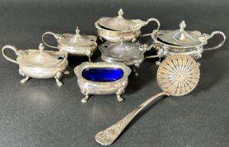 A mixed selection of silver tableware including three toast racks, two three piece condiment sets