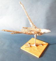 A modernist sculpture of a bird of prey swooping, with a metallic silver painted finish, fastened to
