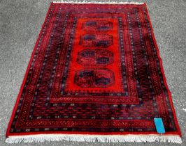 A Turkoman design carpet with four central connected medallions in tones of blue and orange, 190 x