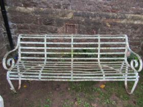 A good painted and weathered 19th century iron strapwork garden bench with simple open scrolled arms