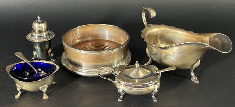 A silver Georgian style sauce boat, a three piece silver condiment set and a silver wine coaster,