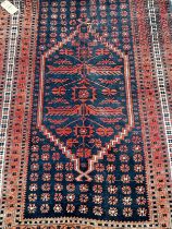 A Persian style rug with a stepped medallion, in tones out red and blue, 175 x 115cm approx