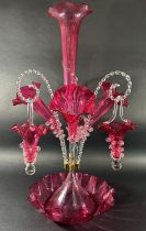 A 19th century cranberry glass epergne with four trumpets and three clear crook-shaped rope twist