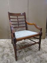 A late Victorian open elbow chair with upholstered pad seat, moulded frame and turned supports