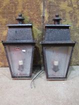 A pair of exterior wall mounted porch lanterns of tapered form with glazed panels (af)