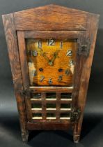 An oak cased free-standing table clock in the Arts & Crafts style, 51 cm high, 24cm wide.