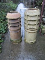 Two weathered buff coloured cylindrical vented chimney pots, slight variant in height and design,