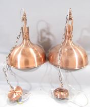 A pair of modern copper industrial lights, with white powder sprayed underside, both with a length