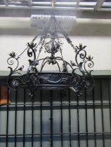 A good quality ironwork hanging ceiling light with decorative open scrollwork, flower head, leaf and