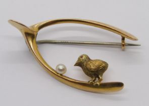 Antique yellow metal novelty wishbone and chick brooch, set with a single pearl simulating an egg,