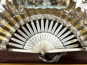 A framed and glazed 19th century paper fan, with a painted boating scene with a chateau in the