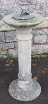 A weathered three sectional cast composition stone sundial with octagonal pillar supporting a