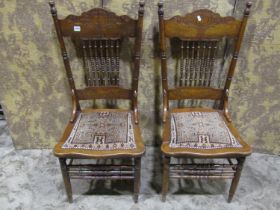 Pair of low dining/side chairs with turned bobbin spindle backs, carved detail and upholstered kelim