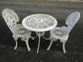 A painted cast aluminium garden terrace table and 2 chairs with decorative pierced details