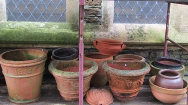 Mixed collection of terracotta planters of varying size and design, some examples with raised relief