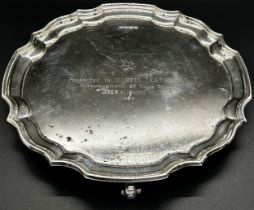 Silver presentation salver with engraved dedication, scallop shaped, raised on scrolled feet,