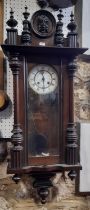 A late 19th century wall clock with enamel dial, the case with split spindle mouldings enclosing