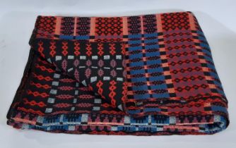 Traditional woollen Welsh blanket in reversible double weave, in red, blue, black and white colours,