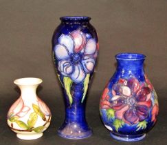 Three Moorcroft vases, two with blue ground detail, and one with white ground, with floral