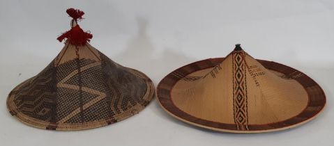 Two mid 20th century Dayak type traditional conical hats from Borneo, both created using a twill