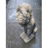 A weathered cast composition stone garden ornament in the form of a seated hound with basket of