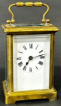 A brass cased carriage clock, the white enamel dial with black Roman numerals, 11 cm high