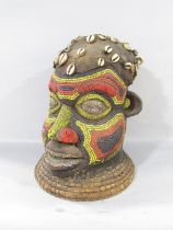 A large African Bamileke or Bamum beaded head, leather capped, and adorned with threaded shells